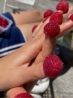 a person holding raspberries in their hands