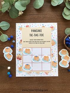 a pancake tic - tac - toe game on a table with blueberries