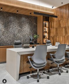 an office with wooden paneling and gray chairs