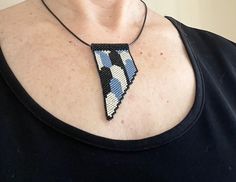 "Denim blue, black, galvanized silver, art deco, asymmetrical, pendant necklace, slide necklace, beaded handmade The model is wearing an 18\" necklace.  Multiple lengths are available at checkout choose 16\", 18\", 20\", or 24\". Beaded handmade asymmetrical pendant necklace.  It hangs on black imitation leather cord with lobster claw and extender chain.  Art deco style necklace slide made using denim blue, black and galvanized silver glass seed beads.   Each bead is woven together into geometric shapes one bead at a time with needle and FireLine braided beading thread.  It measures approximately 2 3/4\" long and 1 3/8\" wide.  Dipped in floor wax to maintain it's shape.  All materials used are nickel/ lead free. **If you have any questions please let me know and be sure to check out my ot Handmade Blue Geometric Jewelry, Black Handmade Necklace With Rectangular Pendant, Floor Wax, Chain Art, Woven Necklace, Beading Thread, Silver Glass, Necklace Beaded, Silver Art