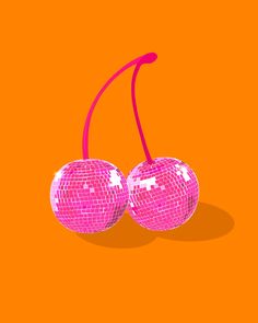 two shiny disco ball cherries with red string on an orange background, one pink and the other white