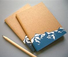 an open notebook with a pencil next to it on top of a gray tablecloth