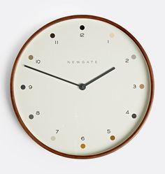 a white clock with brown trim and numbers on the face is shown in front of a white background