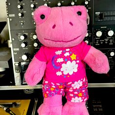 a pink stuffed animal sitting on top of a table next to an amperator