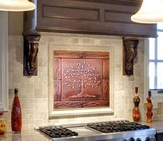 a stove top oven sitting inside of a kitchen next to two lights and a painting on the wall