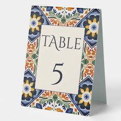 a table number card with an ornate design on the front and bottom, which reads table 5