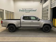 a silver truck parked in front of a building