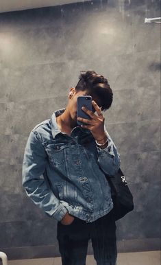 a man taking a selfie in front of a mirror with his cell phone up to his ear