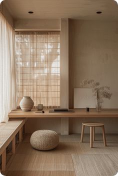 an empty room with a table, stools and vase on the floor in front of a window