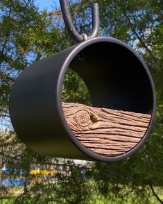 a bird feeder hanging from the side of a tree