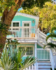 a blue and white house surrounded by trees