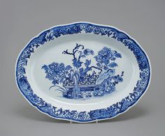 a blue and white plate with an elaborate design on the rim, decorated with flowers