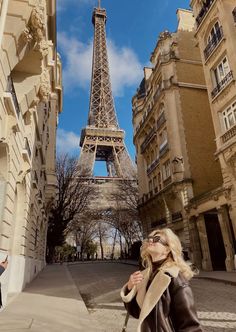 a woman standing in front of the eiffel tower