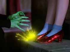 two people in green and red shoes with their hands on the ground holding sparklers