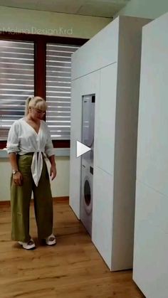 a woman standing in front of an automatic washing machine