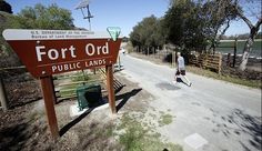 a man walking down the road next to a sign that says fort ford public lands