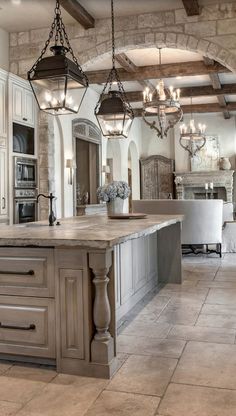 a large kitchen with an island and chandelier hanging from it's ceiling