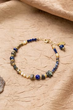 Discover the vibrant and stunning colors of the Blue Moon Collection in this eclectic bracelet! Gold Filled (Lead & Nickel Free) Pyrite, Lapis Lazuli, Sodalite, Abalone, Labradorite, Freshwater Pearl, Mother Of Pearl 7.5-8.5" adjustable length, with gold filled lobster claw clasp We hand select our natural materials, thus there may be slight variations in color and/or size that will not detract from the overall aesthetic. Our unique handcrafted designer jewelry for women is made in America, each Bohemian Lapis Lazuli Gemstone Bracelets, Bohemian Lapis Lazuli Bracelet As A Gift, Bohemian Lapis Lazuli Bracelet For Gift, Bohemian Lapis Lazuli Beaded Bracelets With Natural Stones, Bohemian Beaded Bracelets With Lapis Lazuli Stones, Bohemian Beaded Bracelets With Lapis Lazuli, Handmade Bohemian Lapis Lazuli Bracelets, Artisan Blue Gemstone Beaded Bracelets, Blue Bohemian Gemstone Bracelets