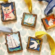 four framed pictures with animals on them hanging from a yellow ribbon next to wallpaper