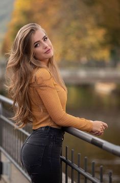 a beautiful young woman leaning on a railing