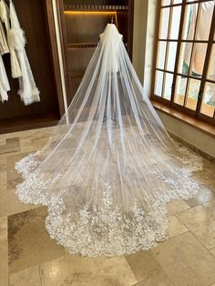 a wedding veil is hanging in front of a window