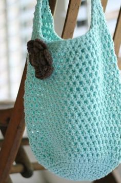 a crocheted bag hanging from a wooden chair