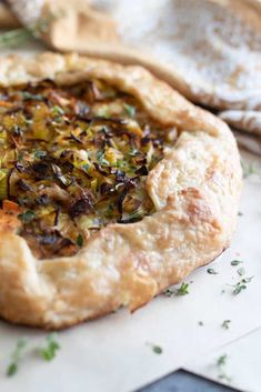 a close up of a pie on a table with other food items in the background