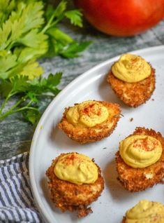 some fried food on a white plate with tomatoes in the background and text overlay that reads cajun style fried deviled eggs