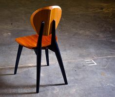 a wooden chair sitting on top of a cement floor