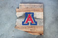 a piece of wood that has the letter a on it and is painted red, white, and blue