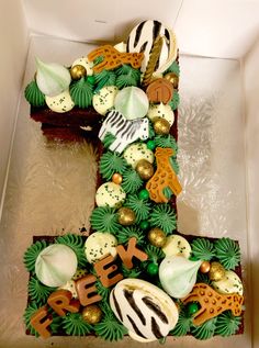 a cake shaped like the letter e is decorated with zebras, giraffes and other animals