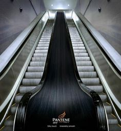 an escalator with long black hair going down it