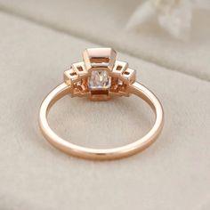 our Bezel Set Art Deco Unique Emerald Cut Moissanite Cluster Baguette Engagement Ring in 14K Rose Gold. This exquisite ring features a dazzling emerald-cut Moissanite stone surrounded by a cluster of sparkling baguette diamonds, all set in a beautiful rose gold band. Rose Gold Diamond Ring With Rose Cut Baguette, Art Deco Baguette Diamond Rectangular Ring, Art Deco Rectangular Baguette Diamond Ring, Timeless Rose Gold Diamond Ring With Baguette Cut, Art Deco Diamond Ring With Square Cut For Wedding, Timeless Rose Gold Baguette Cut Diamond Ring, Art Deco Square Cut Diamond Wedding Ring, Art Deco Rose Gold Diamond Ring, Rose Gold Emerald-cut Baguette Diamond Rings