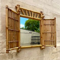 a mirror that is on the side of a building with a wooden frame and window