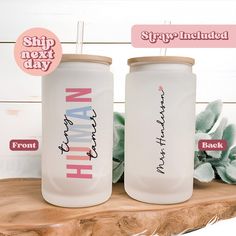 two personalized tumblers sitting on top of a wooden table