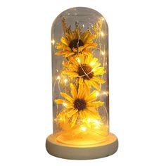 lighted sunflowers in a glass dome with white base and yellow lights on the bottom