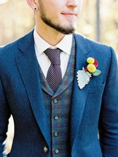 a man wearing a suit and tie with a flower in his lapel