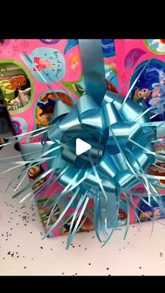 there is a blue bow on top of a gift box with other toys in the background