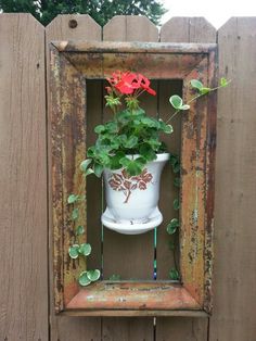 a potted plant in an old window frame with flowers on the outside and inside