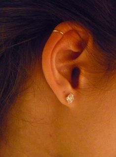 a close up of a person's ear with a ring on top of it