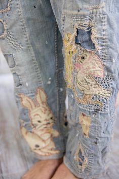 a person wearing ripped jeans with patches on them