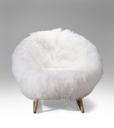 a white sheepskin chair with wooden legs