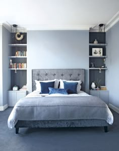 a large bed sitting in a bedroom next to a book shelf