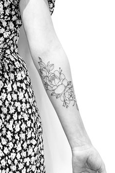 a woman's arm with a flower tattoo on the left side of her arm