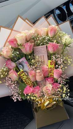 a bouquet of pink roses and baby's breath in a car