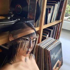 a woman with her face painted to look like she is surrounded by records