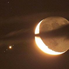 the moon is partially eclipsed in front of two stars and one light emitting from it