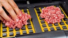 two hamburger patties being cooked on top of a griddle in a grill with someone's hand