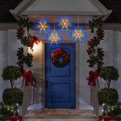 a blue door decorated with christmas wreaths and lights