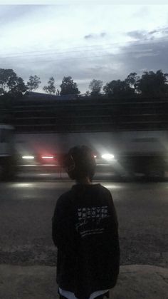 a man standing on the side of a road at night